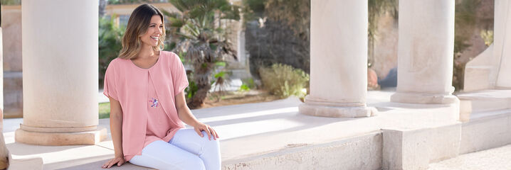 Dame in rosa Bluse und weißer Hose