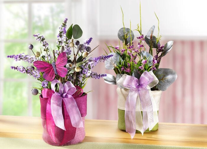 Fr&uuml;hlingsgesteck mit Blumen und Gr&auml;ser im Filzbeutel 