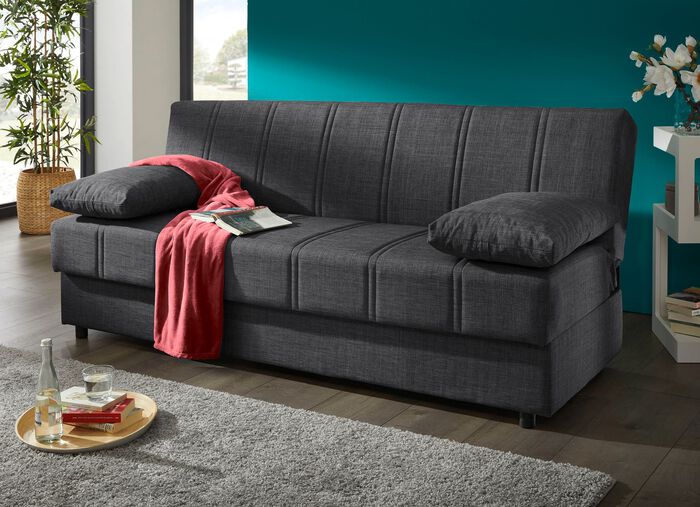 Frei im Raum aufstellbares Schlafsofa mit Dekokissen und Bettkasten 