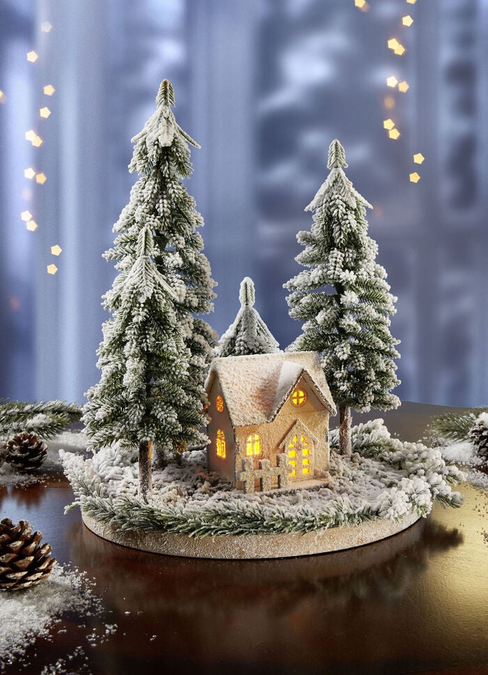 Beleuchtetes Winterhäuschen mit Tannen 
